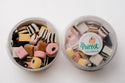Two containers of assorted cookies with a 'The Parrot' brand label on a white background