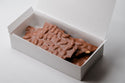 Chocolate bar with nuts in a white box on a light gray background