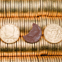 Stack of gold chocolate coins with two coins and a chocolate bar in the center.