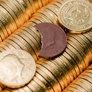Gold chocolate coins with a prominent coin showing 'Liberty' on a white background