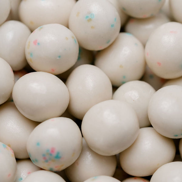 Close-up of white candy balls with colorful specks, likely used as a play item or toy.