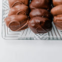 Chocolate truffles on a clear glass plate with a white background