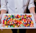 Person holding a tray of colorful candies