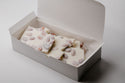 Box of white chocolate with candy eyes on a light gray background